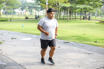 Portrait Of Overweight Male in Sportswear Jogging In The Park