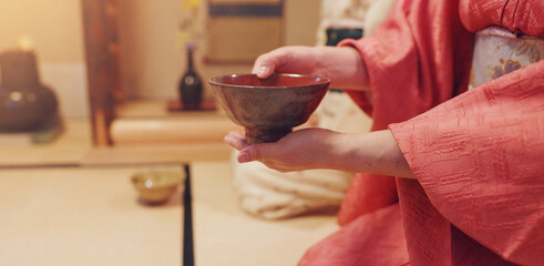 Hands, guest and drink with bowl, chawan and traditional kimono for tea ceremony. Japanese ritual, spirituality and mindfulness with cultural outfit for herbal matcha, respect and home hospitality