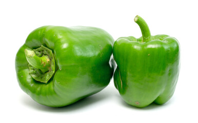 Two green peppers are sitting next to each other on a white background