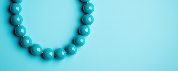 Obraz premium Turquoise jewelry and coastal, A close-up view of a turquoise bead necklace resting on a matching blue surface, highlighting its vibrant color and smooth texture.