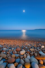 Obraz premium A beach with a large body of water and a large moon in the sky. The moon is reflecting on the water, creating a serene and peaceful atmosphere