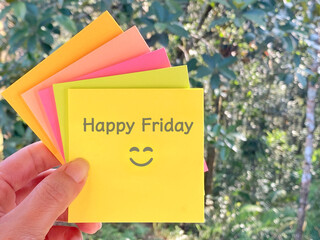 Happy Friday text on paper with smiley icon with nature background. 