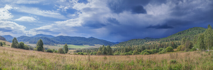 Mountain landscape, meadow and stormy sky, mountain valley, panoramic view