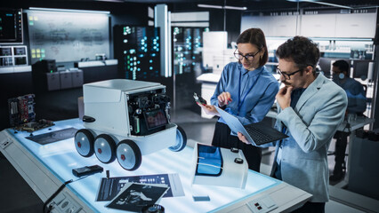 Portrait of Two Colleagues Working in a Research Facility, Using Laptop Computer to Develop a...