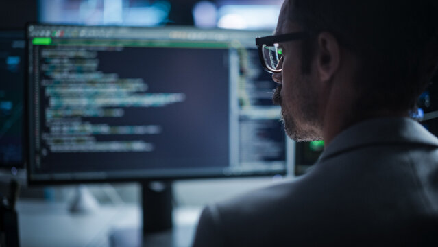Close Up on Young Creative Manager Using Desktop Computer, Writing Code for an Innovative Technological Internet Product Launch. Enthusiastic Professional Developer Working in Modern Office 