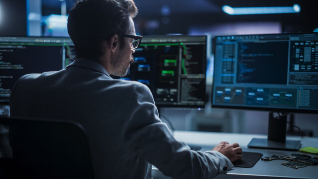 Portrait of Young Creative Manager Using Desktop Computer, Writing Code for an Innovative Technological Internet Product Launch. Enthusiastic Professional Developer Working in Modern Office 