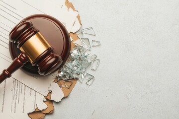 Law restriction prohibition and justice, An image of a gavel resting on torn legal documents with scattered glass shards, symbolizing legal disputes or broken agreements.