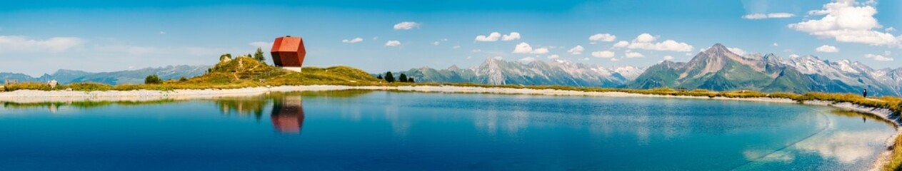 High resolution stitched alpine summer panorama with the famous Capella Granata and reflections in a lake at Mount Penken, Finkenberg, Zillertal valley, Schwaz, Zell am Ziller, Tyrol, Austria