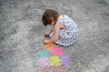 Fototapeta premium little girl drawing by chalks