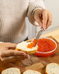 Girl makes a sandwich with red caviar