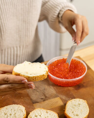 Girl makes a sandwich with red caviar