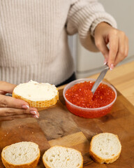 Girl makes a sandwich with red caviar