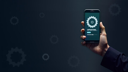 A hand holds a smartphone featuring an "updating" screen with gears, symbolizing software upgrades. Great for content about technology, app development, and digital updates, copy space, blank