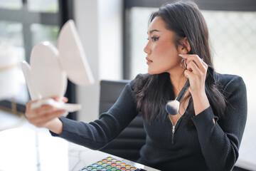 Young Asian girl makeup artist Professional Woman blogger vlogger is showing cosmetics products with recording video Beauty influencer asian girl video online marketing.