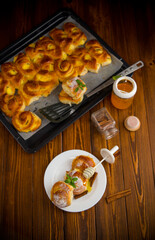 Pastries. Sweet buns with cottage cheese filling and honey in a plate on a wooden table