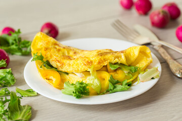 egg roll with sweet pepper and salad, on a wooden table