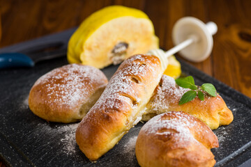 Pastries. Sweet buns with quince and honey filling, on a wooden table