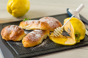 Pastries. Sweet buns with quince and honey filling, on a wooden table