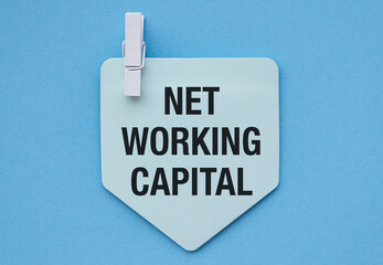Turquoise paper note with Net Working Capital pinned against blue background