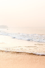 Gentle morning seascape with waves and golden sand