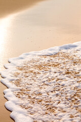 Gentle morning seascape with waves and golden sand