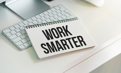 WORK SMARTER text on a paper with magnifier, coffee and keyboard on a white background