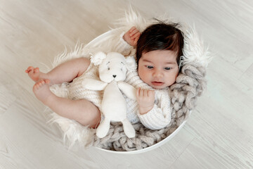 A newborn baby on a white background or in a crib with open eyes, a place for text