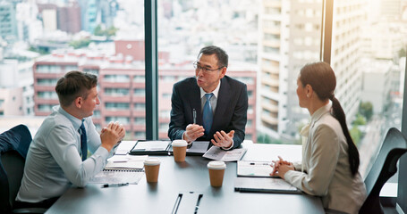 Meeting, client and people in boardroom, documents and negotiation for business deal and discussion. Office, mature man and group with paperwork for proposal, research and sales manager in Japan