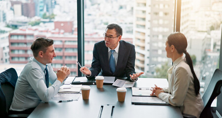 Talking, client and people in boardroom, documents and negotiation for business deal and discussion. Office, mature man and group with paperwork for proposal, research and sales manager in Japan