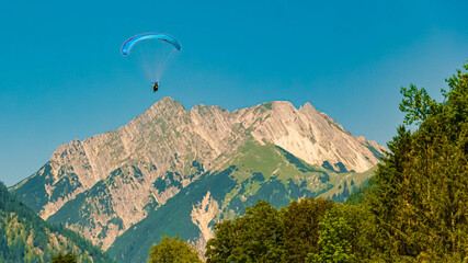 Alpine summer view with a paraglider in flight and the Karwendel mountains at Pertisau, Lake...