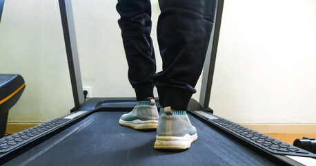 Close up of woman's legs from the side running on a treadmill in a fitness club. Woman running in a gym on a treadmill, exercising concept, cardio exercise, workout, lose weight.