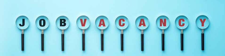 Job search concept, inscription and a lot of magnifying glass with text Job Vacancy on a blue background background, banner