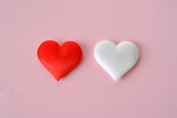 Fototapeta premium two red and white hearts are placed on a pink background top view