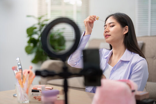 Asian woman demonstrating skincare application during tutorial