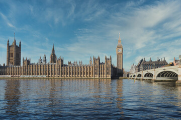 Iconic palace of westminster and big ben reflected in thames river on sunny day, showcasing london's architectural marvels and rich history