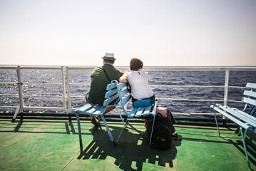 A couple travels on a ship during the summer in the Aegean Sea, Greece.