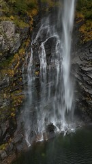 Obraz premium Stunning Waterfall Over Rocky Cliffs