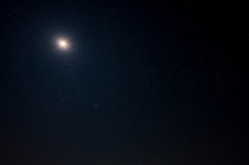 Deep blue background with moon and stars photographed from The Netherlands.