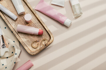 Beauty products background flat lay with skincare, haircare and makeup items on beige, copy space