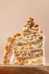 Traditional Spanish Christmas sweets turron with peanuts and nougat stacked on wooden podium with...