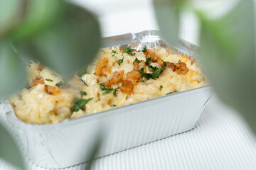 Takeaway pasta with mini shrimps and melted cheese in a cardboard box for delivery