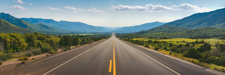 Obraz premium A long, straight road stretches towards the horizon, flanked by lush mountains and a blue sky.