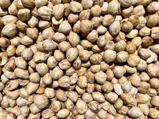 A detailed image showing a close up view of a pile of chickpeas, a type of legume belonging to the bean family, often used as an ingredient in various recipes