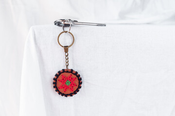 Close-up of a terracotta keychain with 8-pointed star pattern, crafted with a focus on color contrast and intricate detailing, ideal for gifting or adding a unique touch to everyday items