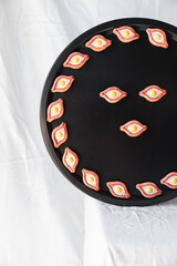 A front view of khachapuri magnets on a black tray, arranged symmetrically for an elegant and contemporary look, perfect for home or kitchen decor