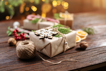 Christmas and zero waste, eco friendly packaging gift on wooden background under christmas tree. Eco christmas holiday concept. Sustainable christmas