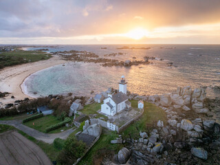 Vue aerienne d'un phare face à la mer et au coucher de soleil . Phare de Pontusval sur la côte...