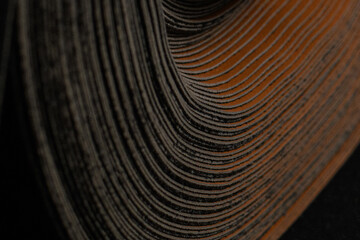 A close-up of a rolled-up material, revealing a complex pattern of layers. The warm, earthy tones...