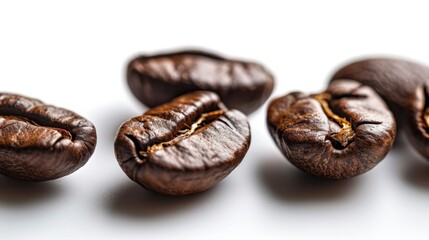 Obraz premium Coffee beans in a random cluster on a white surface, highlighting their natural shapes