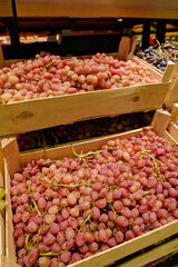 Crates overflowing with fresh green and red grapes are stacked in a supermarket, ready for sale. Focus on abundance and natural produce.